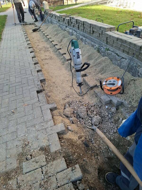 Meglévő térkőburkolat bontása vésőgéppel, mellette terméskő támfal és elterített murvaágyazat